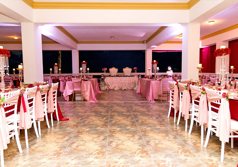 Elegant dining area decorated with pink and red table settings for a celebration.