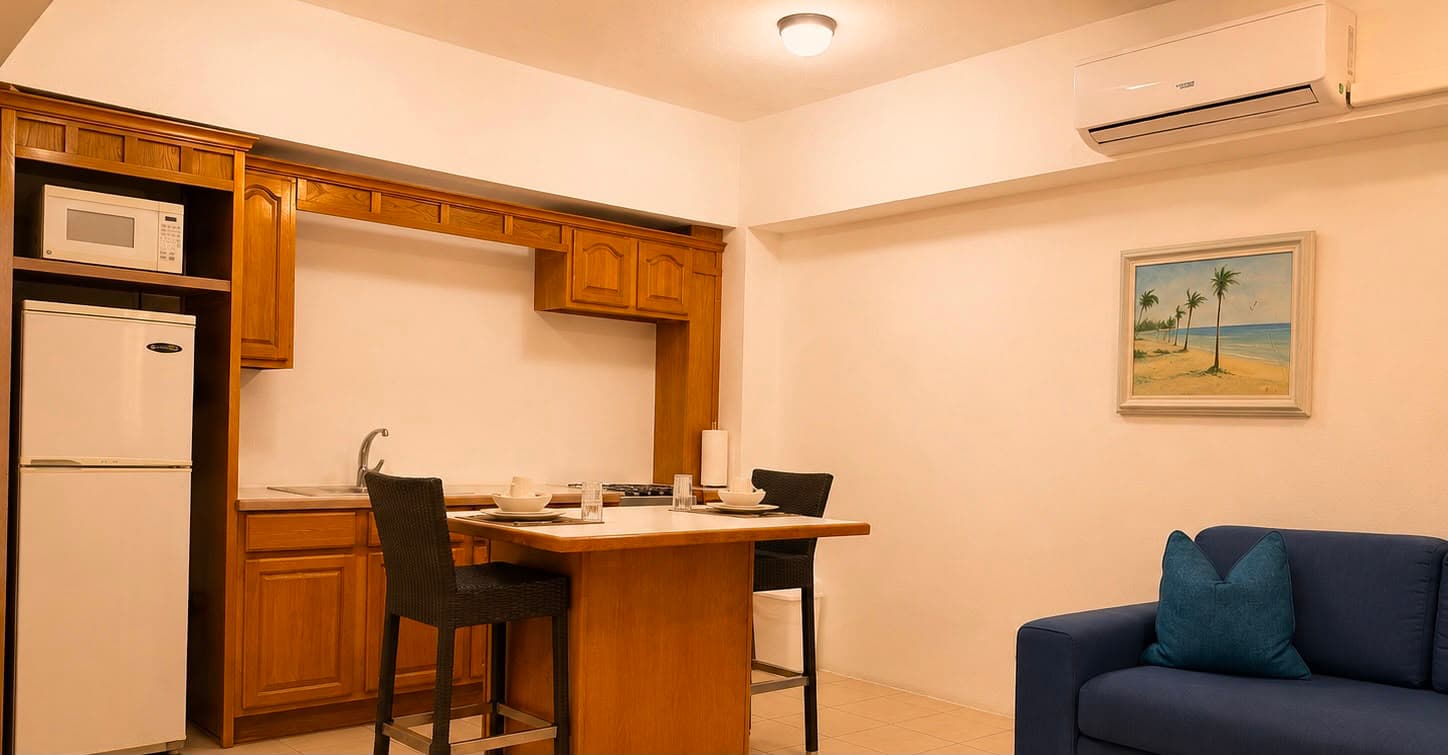 A modern kitchen and dining area featuring wooden cabinets, a dining table, and a blue sofa.