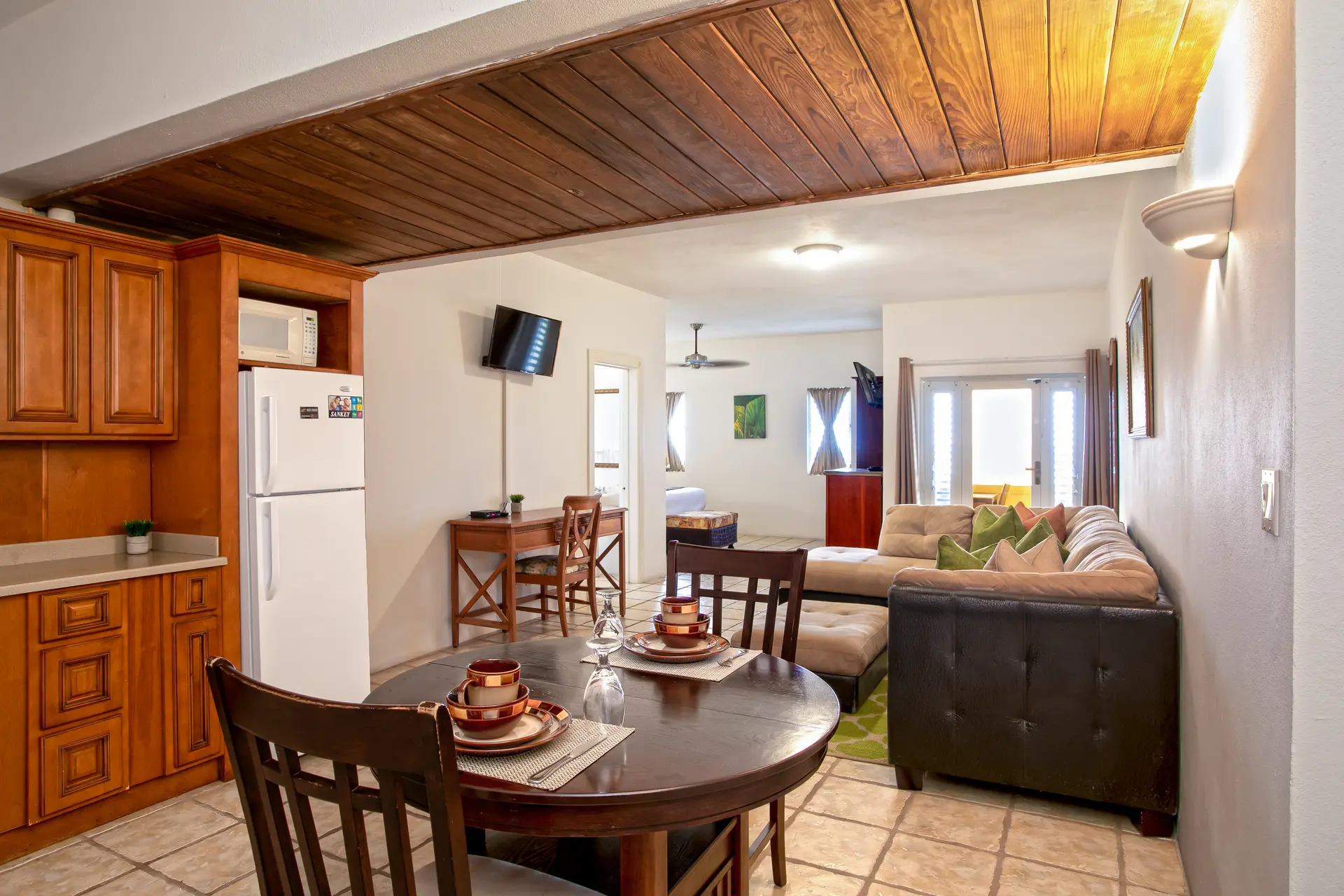A cozy living space featuring a kitchen, dining area, and seating arrangement with natural light.