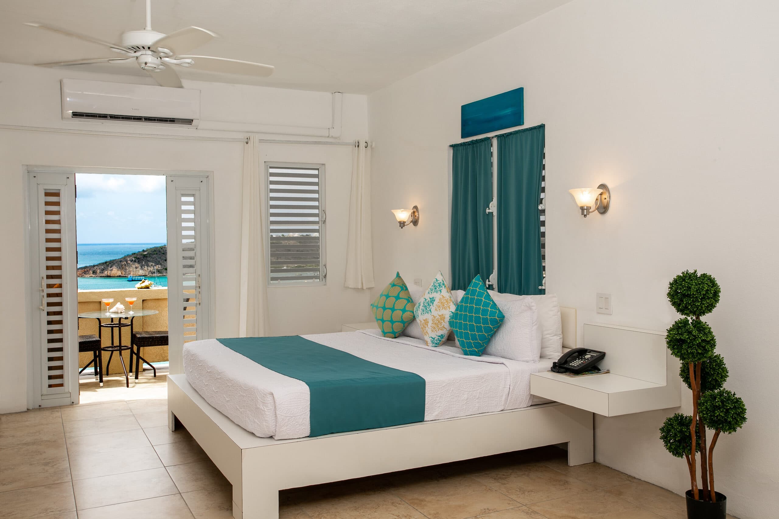 A bright, modern bedroom with a king-sized bed, ocean views, and a private balcony.