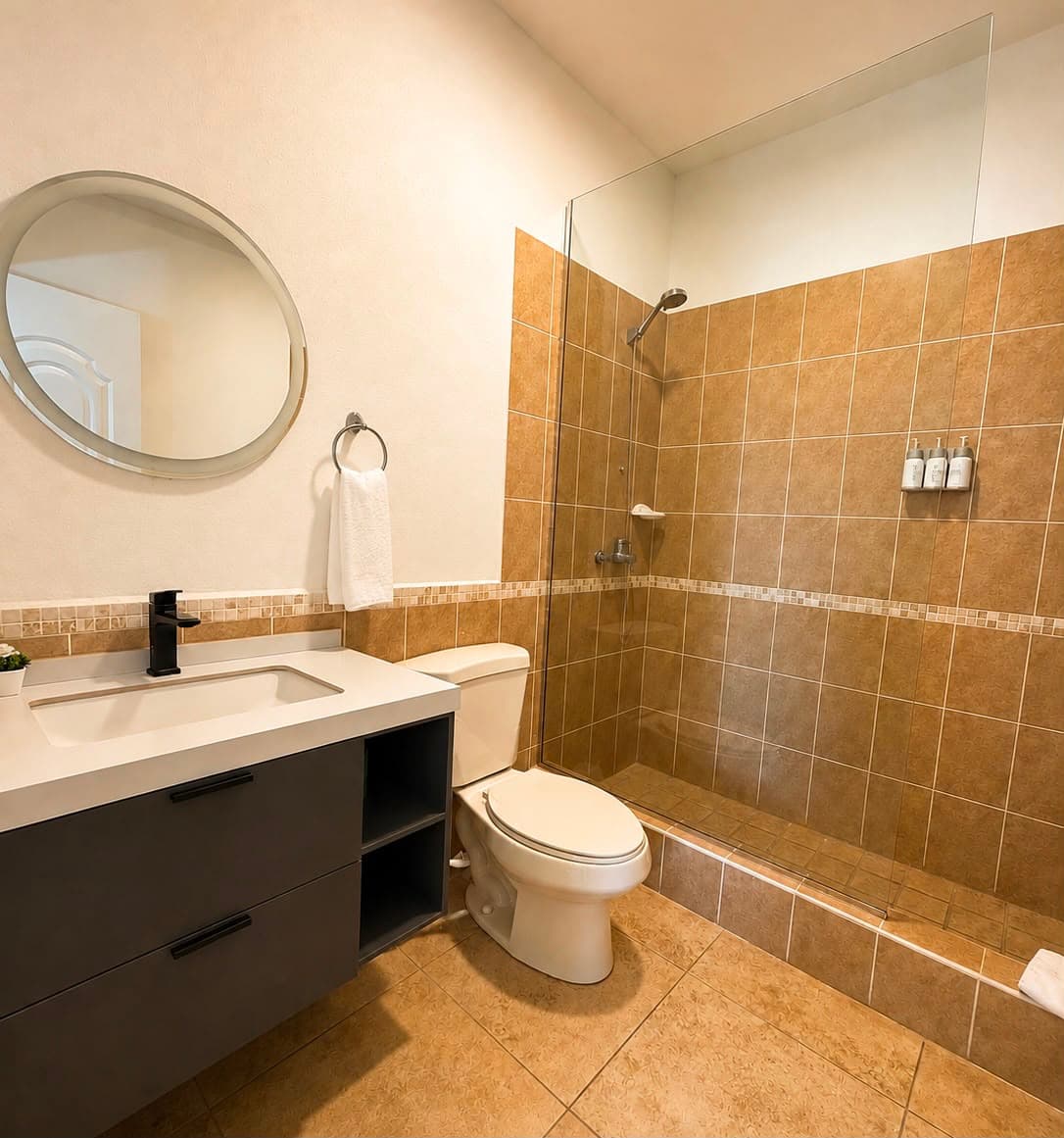 Modern bathroom featuring a shower, toilet, and sleek vanity with a mirror.